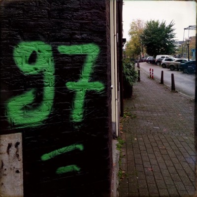 sprayed green number 97 on a brick wall in Amsterdam