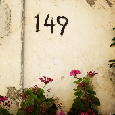 hand written black house number 149 on a wall on Crete