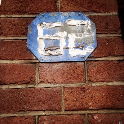 white hand written house number 62 on a metal blue plate in Amsterdam