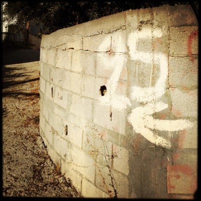 hand written white number 25 on brick wall on Crete