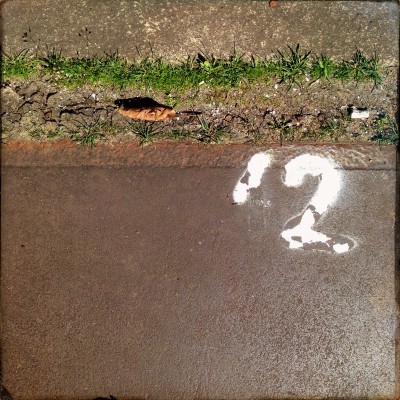 white hand written number 12 on the streets of Amsterdam