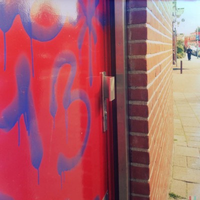 blue sprayed number 13 on a red door in Amsterdam