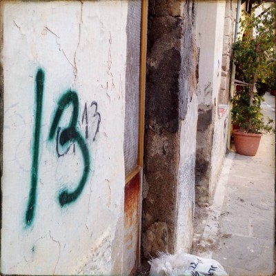 green hand written number 13 on a white wall in Rethymno Crete
