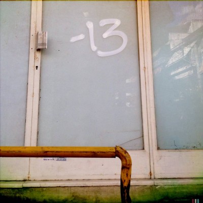 white hand written number 13 on a glass door in Athens