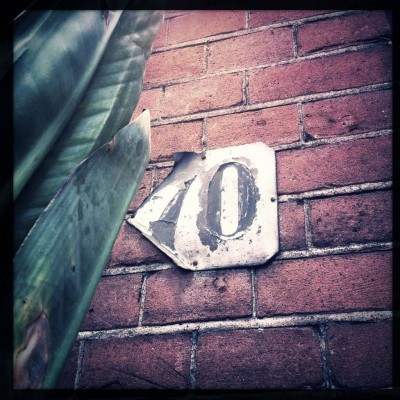 old black house number 70 on a brick wall in Amsterdam