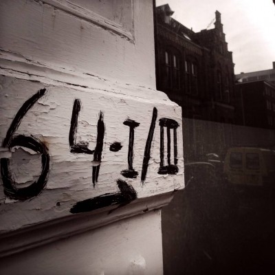 black hand written house number 64 next to a city reflection in Amsterdam