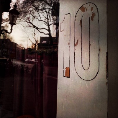 outlined house number 10 and the reflection of Amsterdam on the window