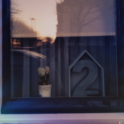 3D house number 2 behind a window that reflects the street somewhere in Katwijk