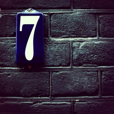 blue house number 7 on a brick wall in Amsterdam