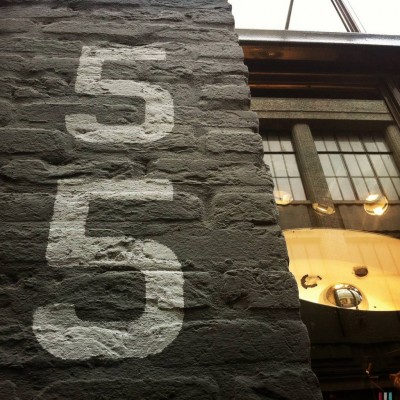 white number 55 on a brick wall in Amsterdam