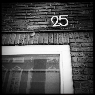 metal house number 25 on a brick wall in Amsterdam