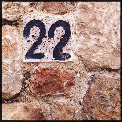 Black house number 22 on a stone wall in Athens