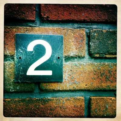 House number 2 on a brick wall with spider web in Amsterdam