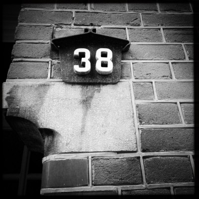 white house number 38 on a brick wall in Amstrdam