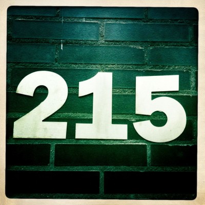 House number 215 on a brick wall in Amsterdam
