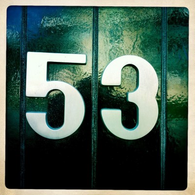 silver house number 53 on a dark green door in Katwijk